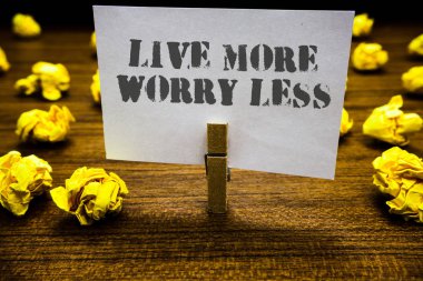 Yaşamak daha fazla endişe daha az gösterilen metin işareti. Kavramsal fotoğraf var olmak dikkatsiz bir iyi niyet motivasyon hayat ataç grip beyaz sayfa gri metin odunsu yere koydu bulanık sarı lob ile keyfini çıkarın