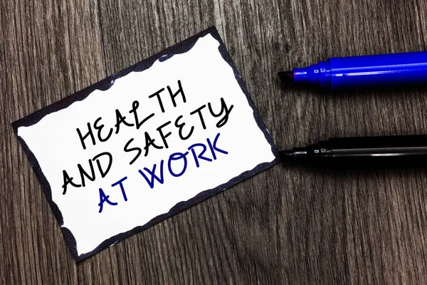 Word writing text Health And Safety At Work. Business concept for Secure procedures prevent accidents avoid danger Black bordered page with texts laid black and blue pen on wooden floor