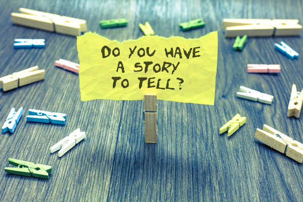 Handwriting text Do You Have A Story To Tell question. Concept meaning Storytelling Memories Tales Experiences Paperclip hold written torn page many clips laid on bluish wooden floor
