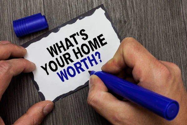 Handwriting text What s is Your Home Worth question. Concept meaning Value of a house Property Cost Price Rate Gray wooden deck hand hold black marker written black lined sticky note