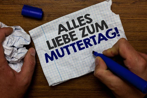 Word writing text Alles Liebe Zum Muttertag. Business concept for Happy Mothers Day Love Good wishes Affection Hand hold paper lob and blue marker wooden base with torn white written page