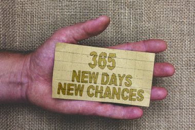 Kavramsal el 365 yeni gün yeni bir şans gösterilen yazma. Başka bir yıl takvim fırsatları kalın gri kağıt kelimeler insan eli Jüt çuval arka plan ile başlayan vitrine iş fotoğraf