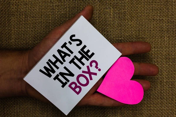 Word writing text What s is In The Box question. Business concept for Curiosity Opening a gift Surprise package Human hand touched white page with letter and love symbol sack base