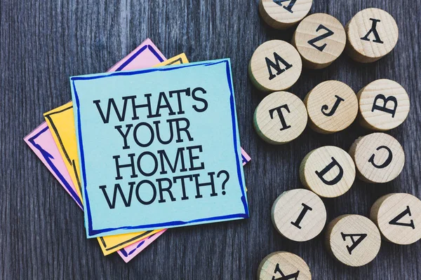 Handwriting text What s is Your Home Worth question. Concept meaning Value of a house Property Cost Price Rate Black wooden deck written sticky note beside some round woody alphabets