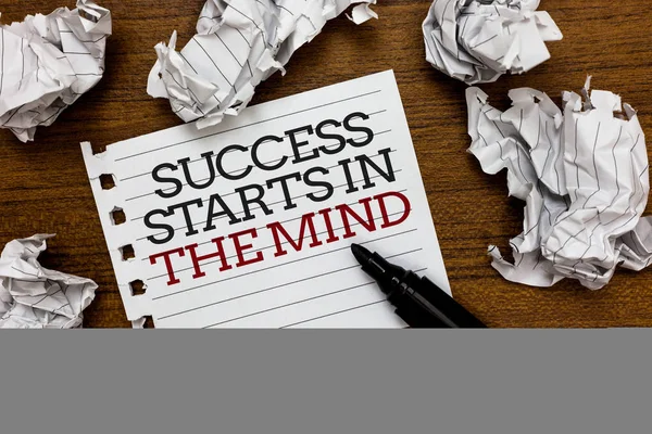 Text sign showing Success Starts In The Mind. Conceptual photo Have positive thoughts accomplish what you want Paper lumps laid randomly around white notepad touch black pen on woody floor