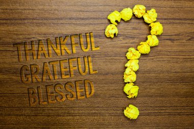 Word writing text Thankful Grateful Blessed. Business concept for Appreciation gratitude good mood attitude Wooden floor with some letters yellow paper lumps formed question mark clipart