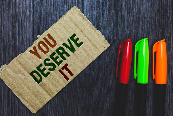 Writing note showing You Deserve It. Business photo showcasing Reward for something well done Deserve Recognition award Cardboard with letters on grey wooden desk colorful pens laid rank