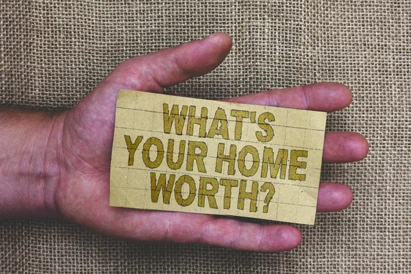 Conceptual hand writing showing What s is Your Home Worth question. Business photo showcasing Value of a house Property Cost Price Rate Thick gray paper with words human hands jute sack background
