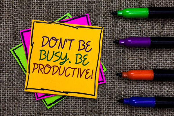 Text sign showing Don t not Be Busy. Be Productive. Conceptual photo Work efficiently Organize your schedule time Written on some colorful sticky note 4 pens laid in rank on jute base