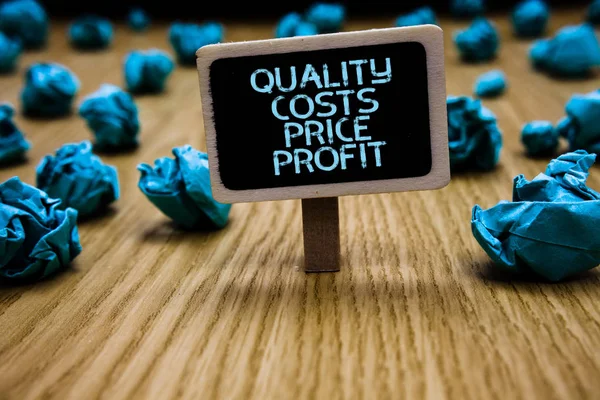 Word writing text Quality Costs Price Profit. Business concept for Balance between wothiness earnings value Paperclip hold black paperboard with text blue paper lobs on wooden floor