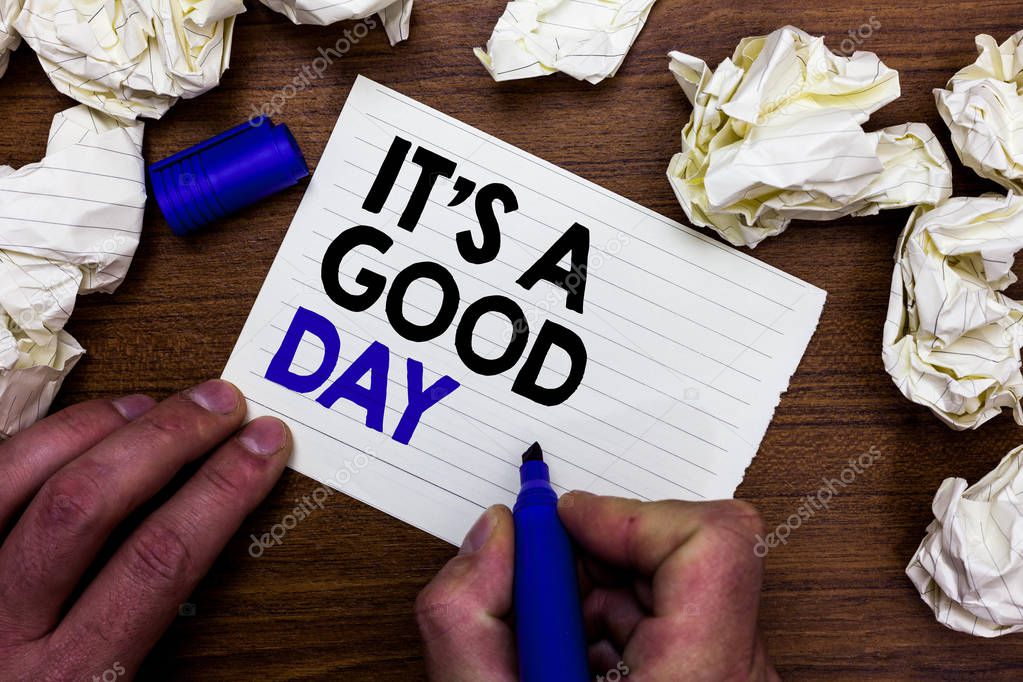 Writing note showing It s is A Good Day. Business photo showcasing Happy time great vibes perfect to enjoy life beautiful Hand holding marker write words paper lob scatter around woody desk