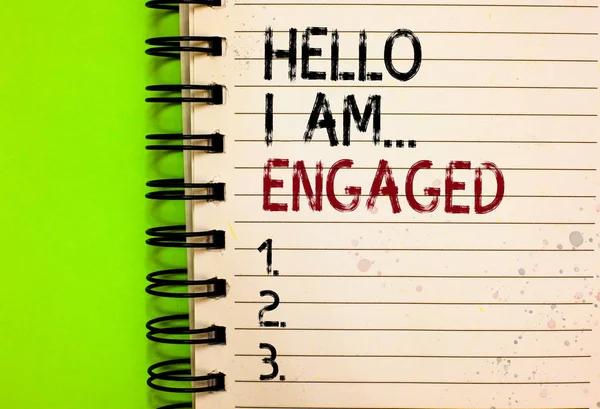 Word writing text Hello I Am... Engaged. Business concept for He gave the ring We are going to get married Wedding Written black and red text and number on white notepad green background
