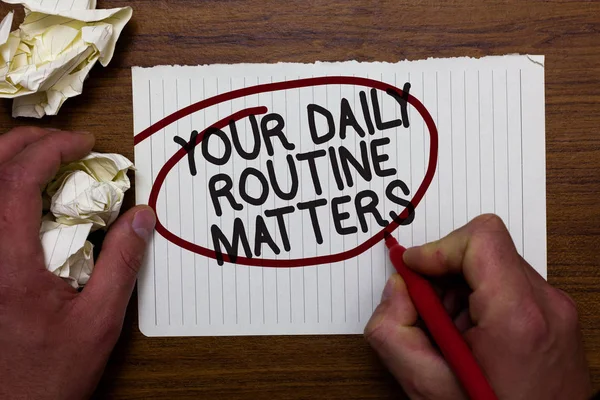 Text sign showing Your Daily Routine Matters.. Conceptual photo Have good habits to live a healthy life Hand hold paper lob and red pen red circled black words on white paper