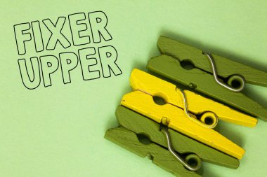 Text sign showing Fixer Upper. Conceptual photo house in need of repairs used chiefly connection with purchase Three green yellow vintage clothespins clear background Holding things clipart