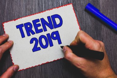 Trend 2019 gösterilen Not yazma. Geçerli yıldaki marker kağıt kırmızı kenarlıklar hızlı fikirler ahşap arka plan tutan adam kısa süre için ünlüdür şeyler vitrine iş fotoğraf