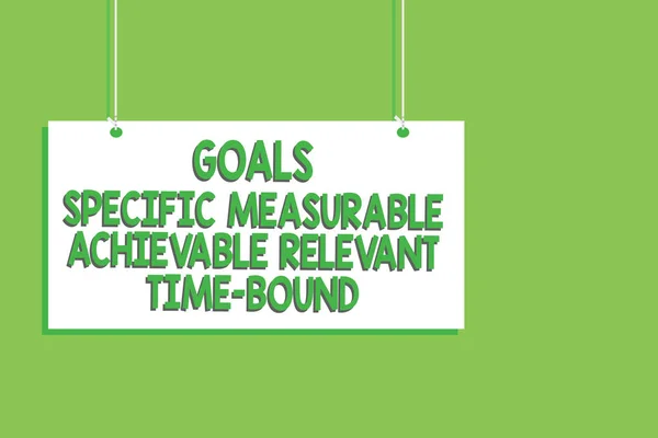 Handwriting text Goals Specific Measurable Achievable Relevant Time Bound. Concept meaning Strategy Mission Hanging board message communication open close sign green background