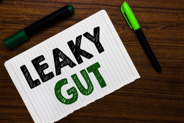 Conceptual hand writing showing Leaky Gut. Business photo text A condition in which the lining of small intestine is damaged Notebook paper markers wooden background communicating ideas clipart