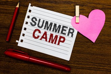 Word writing text Summer Camp. Business concept for Supervised program for kids and teenagers during summertime. Notebook piece paper markers clothespin holding heart wooden background clipart