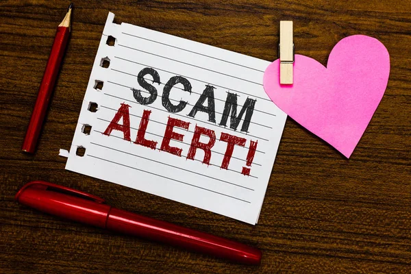 Word writing text Scam Alert. Business concept for warning someone about scheme or fraud notice any unusual Notebook piece paper markers clothespin holding heart wooden background