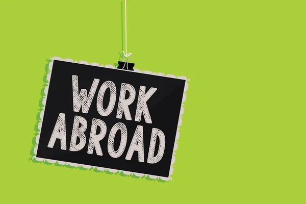 Conceptual hand writing showing Work Abroad. Business photo text Immersed in a foreign work environment Job Overseas Non Local Hanging blackboard message communication sign green background