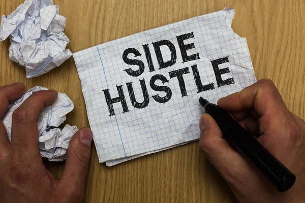 Writing note showing Side Hustle. Business photo showcasing way make some extra cash that allows you flexibility to pursue Man holding marker notebook paper crumpled papers several tries