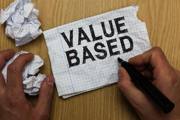 Writing note showing Value Based. Business photo showcasing Considering the product worth in satisfying the customer Man holding marker notebook paper crumpled papers several tries