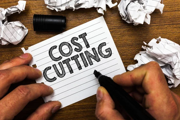 Text sign showing Cost Cutting. Conceptual photo Measures implemented to reduced expenses and improved profit Man holding marker notebook page crumpled papers several tries mistakes