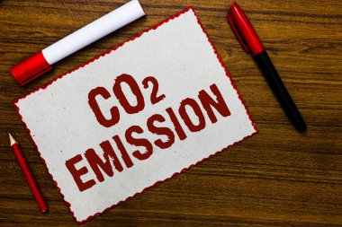 CO2 emisyonu yazma el yazısı metin. Releasing sera gazlarının atmosfere zaman beyaz kağıt kırmızı üzerinde anlam kavramı fikirler iletişim işaretleri ahşap arka plan sınırları