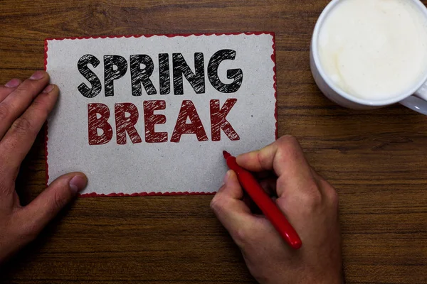 Word tekst intoetsen voorjaarsvakantie. Business concept voor vakantie periode op school en universiteiten tijdens lente Man met marker communiceren ideeën stuk papier houten tafel kop koffie. — Stockfoto