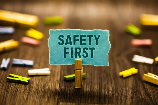 Szöveg írása a biztonság az első szó. Üzleti koncepció elkerülése érdekében minden felesleges kockázatot Live biztonságosan kell gondos fizetni figyelmet ruhacsipesz gazdaság kék papír Megjegyzés emlékeztető clothespins fa padló. — Stock Fotó
