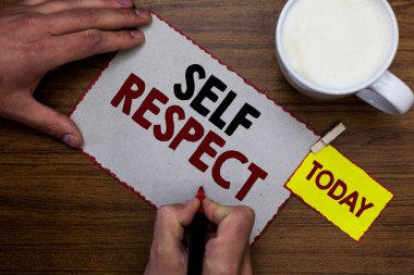 Kavramsal el öz saygı gösterilen yazma. İş fotoğraf metin gurur ve kendini güven marker defter hatırlatma ahşap masa fincan kahve tutan adam kendini savun.