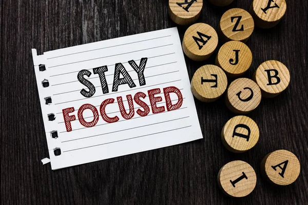 Word writing text Stay Focused. Business concept for Be attentive Concentrate Prioritize the task Avoid distractions Piece notebook paper circle letters ideas inspiration wooden background. — Stock Photo, Image