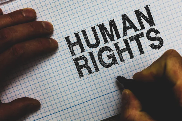 Handwriting text Human Rights. Concept meaning Moral Principles Standards Norms of a people protected by Law Man holding marker communicating ideas important messages squared paper. — Stock Photo, Image