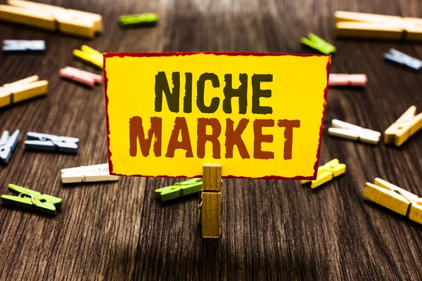 Handwriting text writing Niche Market. Concept meaning Subset of the market on which specific product is focused Clothespin holding yellow paper note several clothespins wooden floor.