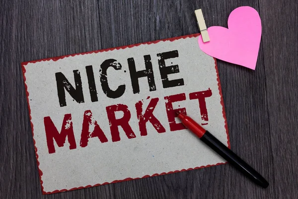 Text sign showing Niche Market. Conceptual photo Subset of the market on which specific product is focused White page red borders marker clothespin holds paper heart wood background.