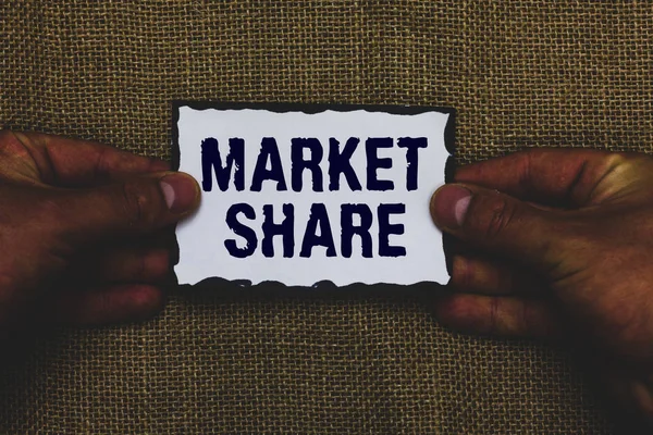 Handwriting text Market Share. Concept meaning The portion of a market controlled by a particular company Man holding piece paper black borders jute background Communicate ideas.