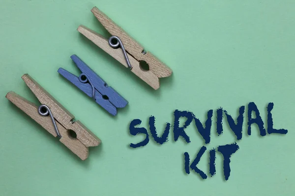 Conceptual hand writing showing Survival Kit. Business photo showcasing Emergency Equipment Collection of items to help someone Three brown blue vintage clear background Holding things.