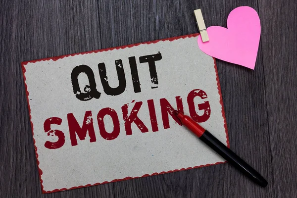 Text sign showing Quit Smoking. Conceptual photo Discontinuing or stopping the use of tobacco addiction White page red borders marker clothespin holds paper heart wood background. — Stock Photo, Image