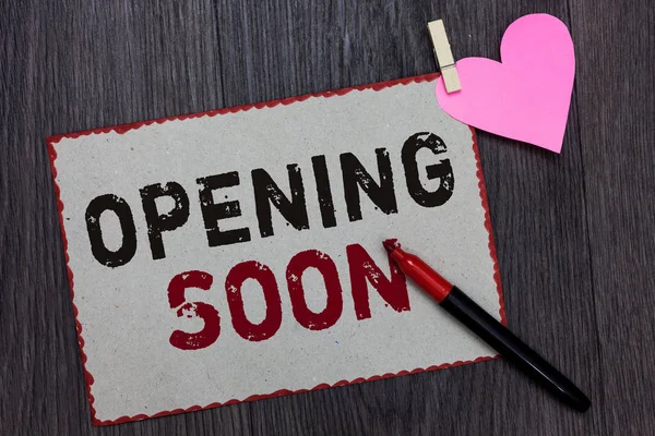 Text sign showing Opening Soon. Conceptual photo Going to be available or accessible in public anytime shortly White page red borders marker clothespin holds paper heart wood background.