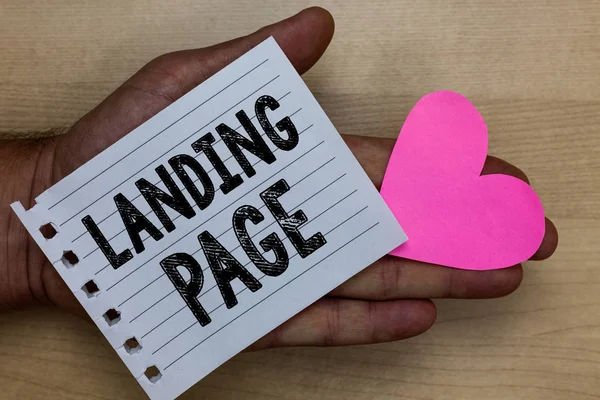 Text sign showing Landing Page. Conceptual photo Website accessed by clicking a link on another web page Man holding piece notebook paper heart Romantic ideas messages feelings. — Stock Photo, Image