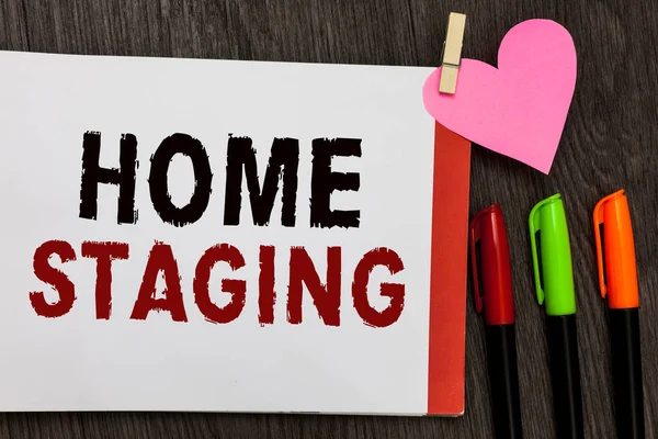 Word schrijven tekst Home Staging. Businessconcept voor Act van de voorbereiding van een prive-woning te koop in de markt notitieblok openen pagina markeringen wasknijper houden van houten hart-achtergrond papier. — Stockfoto