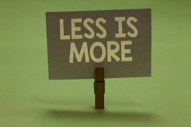 Word metin daha az olduğunu daha yazma. İş kavramdır için sanatsal sorun Minimalist yaklaşım daha etkili Clothespin gri kağıt önemli iletişim iletiyi fikirler holding.