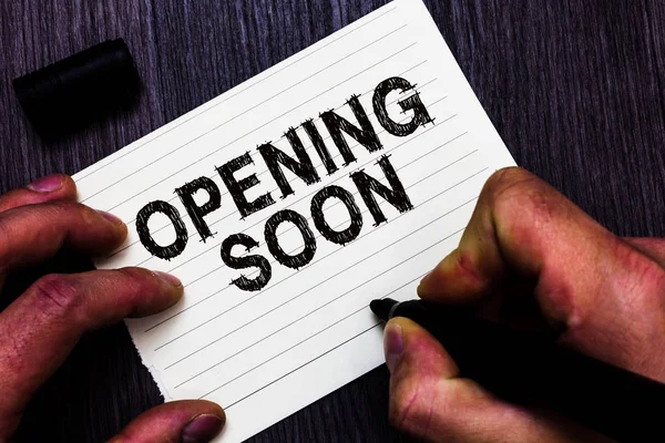 Text sign showing Opening Soon. Conceptual photo Going to be available or accessible in public anytime shortly Man holding marker notebook page communicate ideas Wooden background.