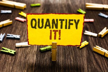 Birkaç clothespins ahşap zemin sarı kağıt Not tutarak Clothespin ölçmek onu ölçü birimi boyutunu veya miktarı bir şey ve hızlı olarak anlam kavramı yazma el yazısı metin numaraları.