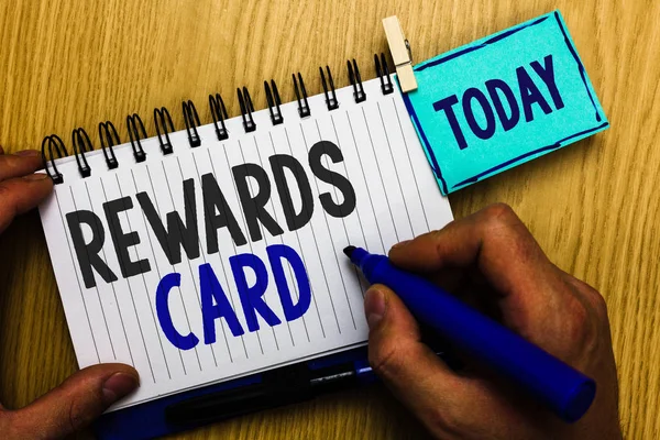 Conceptual hand writing showing Rewards Card. Business photo showcasing Help earn cash points miles from everyday purchase Incentives Man holding marker expressing ideas notebook reminder wood.