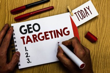 Coğrafi hedefleme yazma el yazısı metin. Dijital reklamları sayısı IP adresi Adwords kampanyaları konum işaretçisi defter clothespin hatırlatma ahşap masa fincan kahve holding adam anlam kavramı.