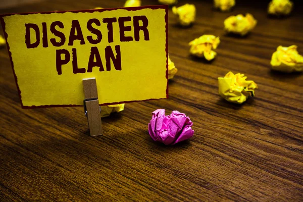 Writing note showing Disaster Plan. Business photo showcasing Respond to Emergency Preparedness Survival and First Aid Kit Clothespin holding yellow paper note crumpled papers several tries. — Stock Photo, Image