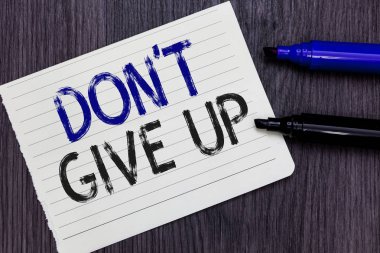 Writing note showing Don t not Give Up. Business photo showcasing Determined Persevering Continue to Believe in Yourself Notebook Paper Reminder Communicating ideas Markers Wooden background. clipart
