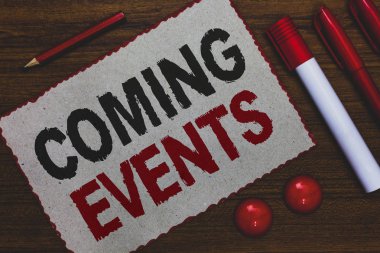 Kavramsal el Coming Events gösterilen yazma. Yakında gelecek planlanan olay fotoğraf iş vitrine karşılamak yaklaşan gelecekte beyaz kağıt kırmızı kenarlıklar belirteçleri kalemleri ahşap arka plan.