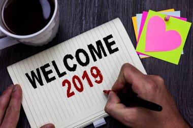 Kavramsal el hoş geldiniz 2019 gösterilen yazma. İş fotoğraf metin yeni yıl kutlama motivasyon fikirler ahşap masa kahve Kupası kupa vererek başlamak alkış Tebrikler adam holding işaretleyici.